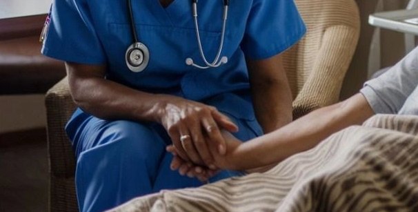 A nurse in scrubs holding a patient's hand